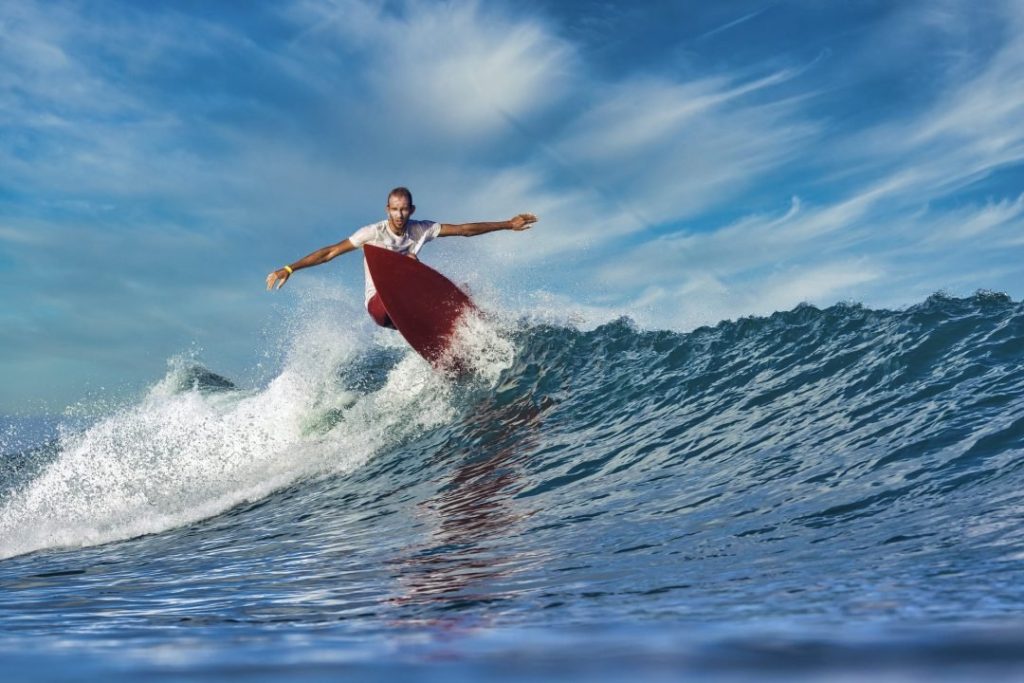MALE SURFER ON A BLUE WAVE AT SUNNY DAY - Jack's Gland Surfcamp